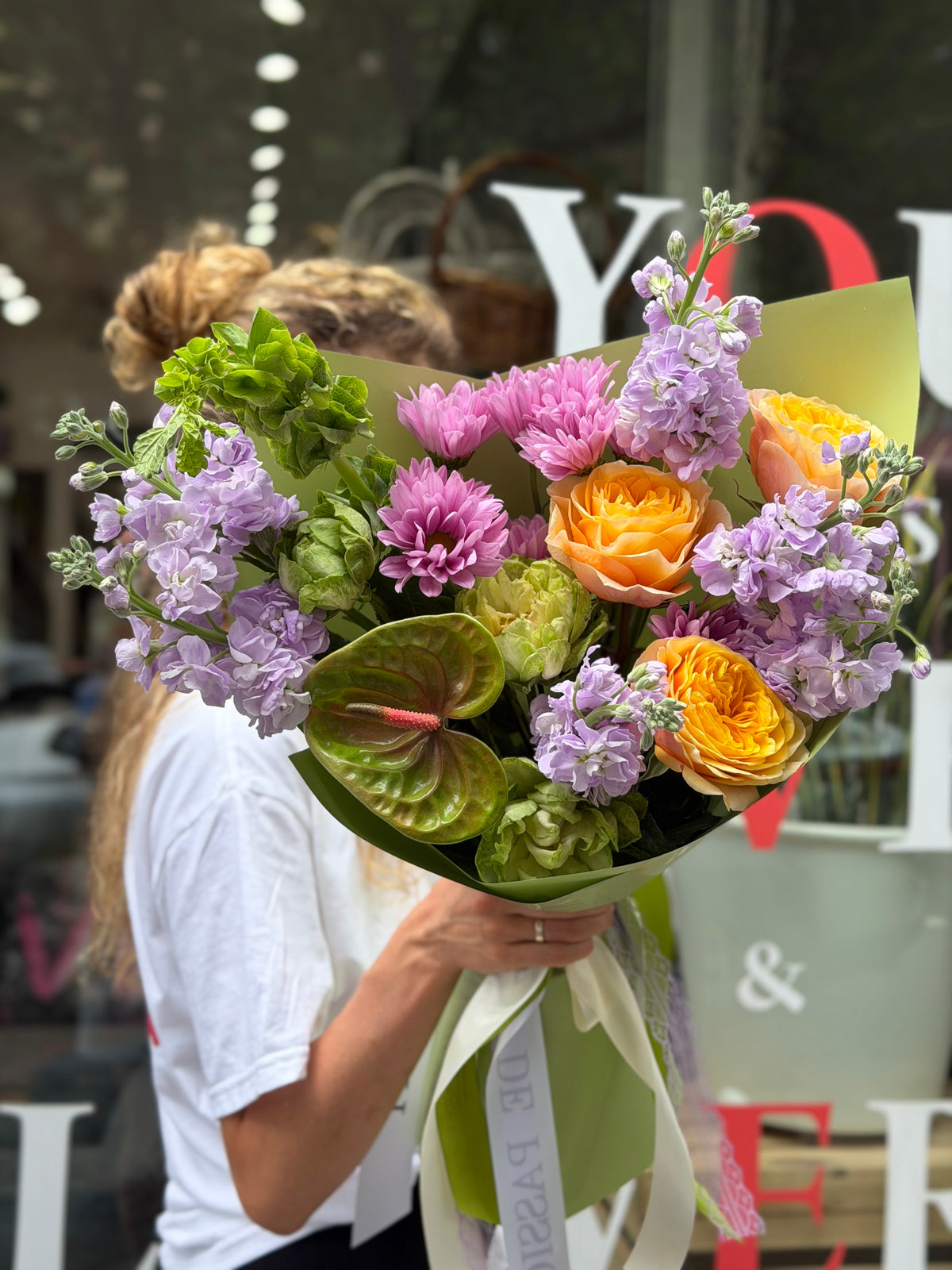 “Lavender Citrus Harmony” (Anthurium, Cream Garden Roses, Veggie Roses, Stocks, Bells of Ireland)